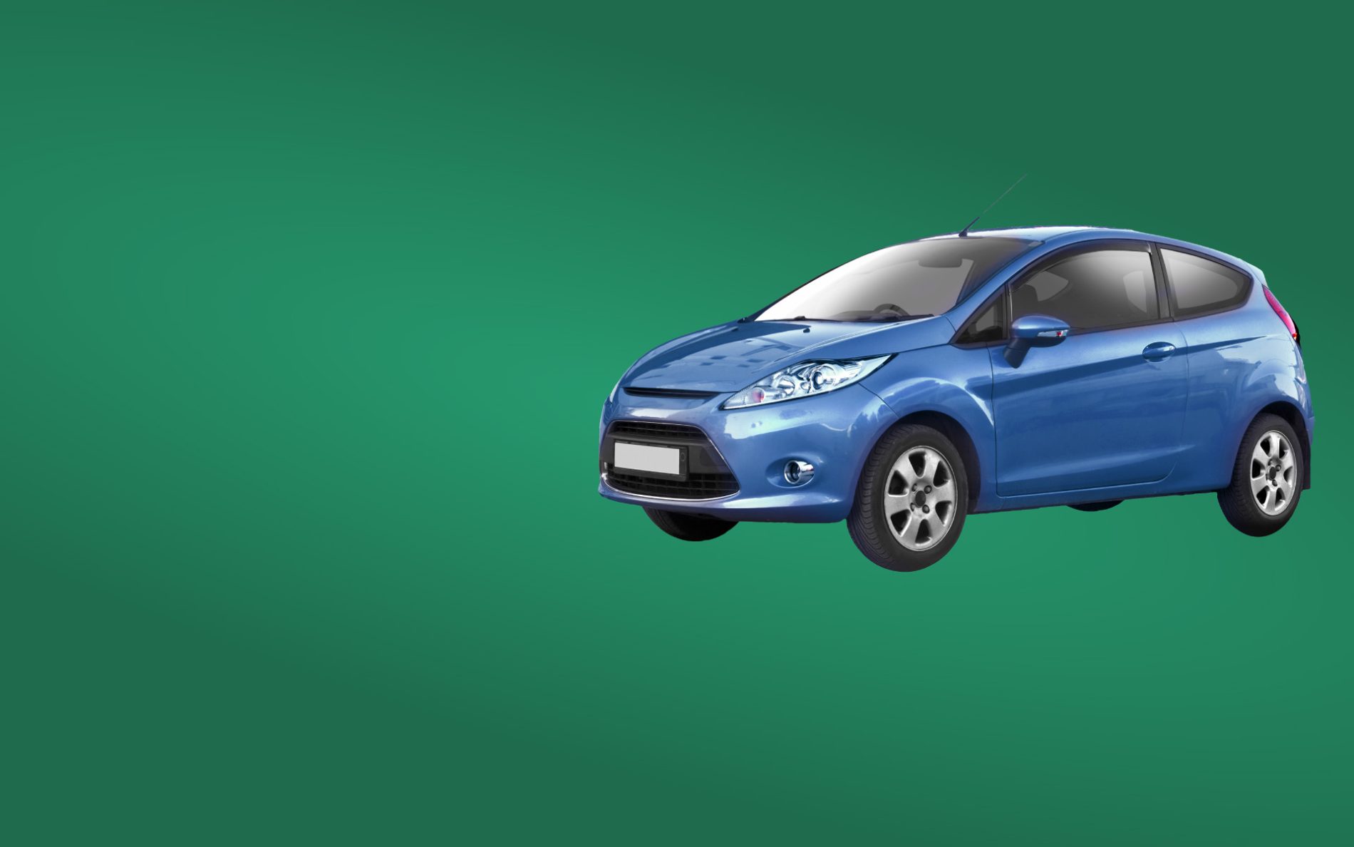 Auto marki ford niebieskiego koloru na zielonym tle.